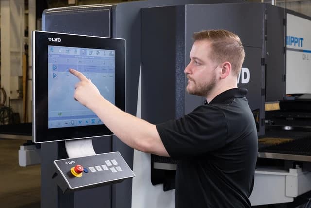 Operator working at the LVD Touch-PL touchscreen control beside the machine