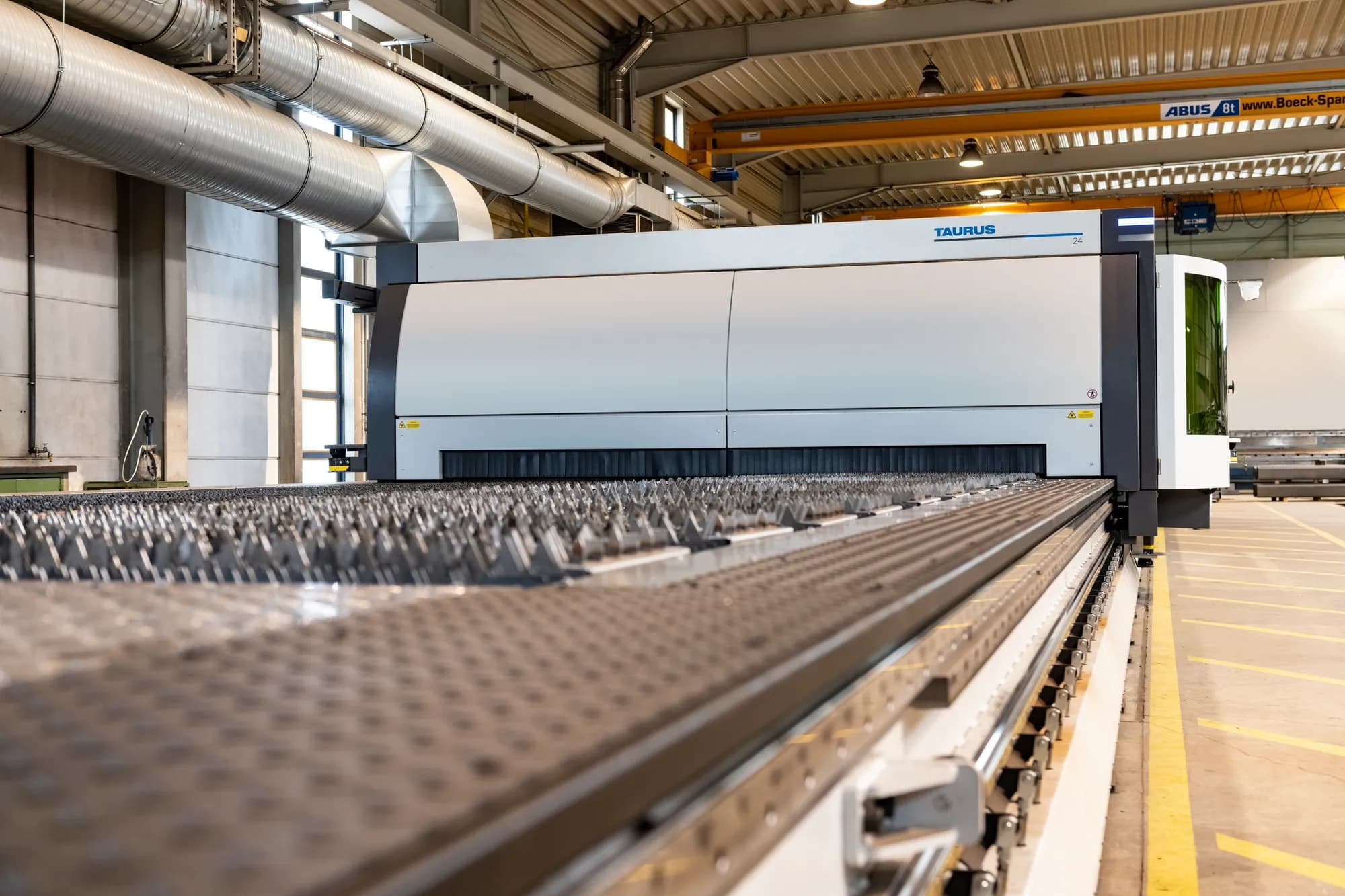 An LVD Taurus large-format fibre laser cutting machine on the shop floor, its slat bed running the length of the frame